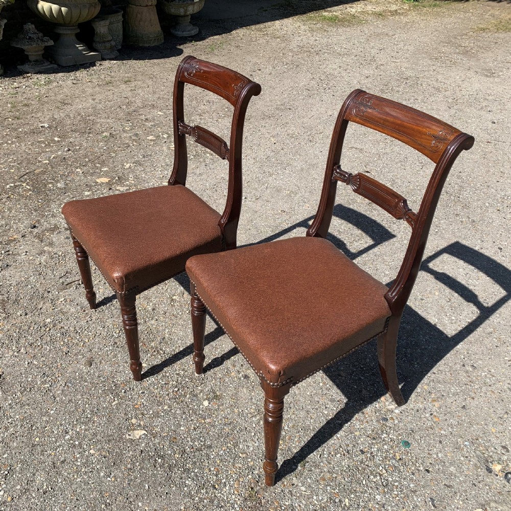 A set of four Regency mahogany dining chairs with carved bar backs, dark brown upholstered seats, and turned front legs. View II