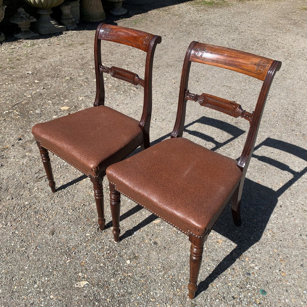 A set of four Regency mahogany dining chairs with carved bar backs, dark brown upholstered seats, and turned front legs. View III