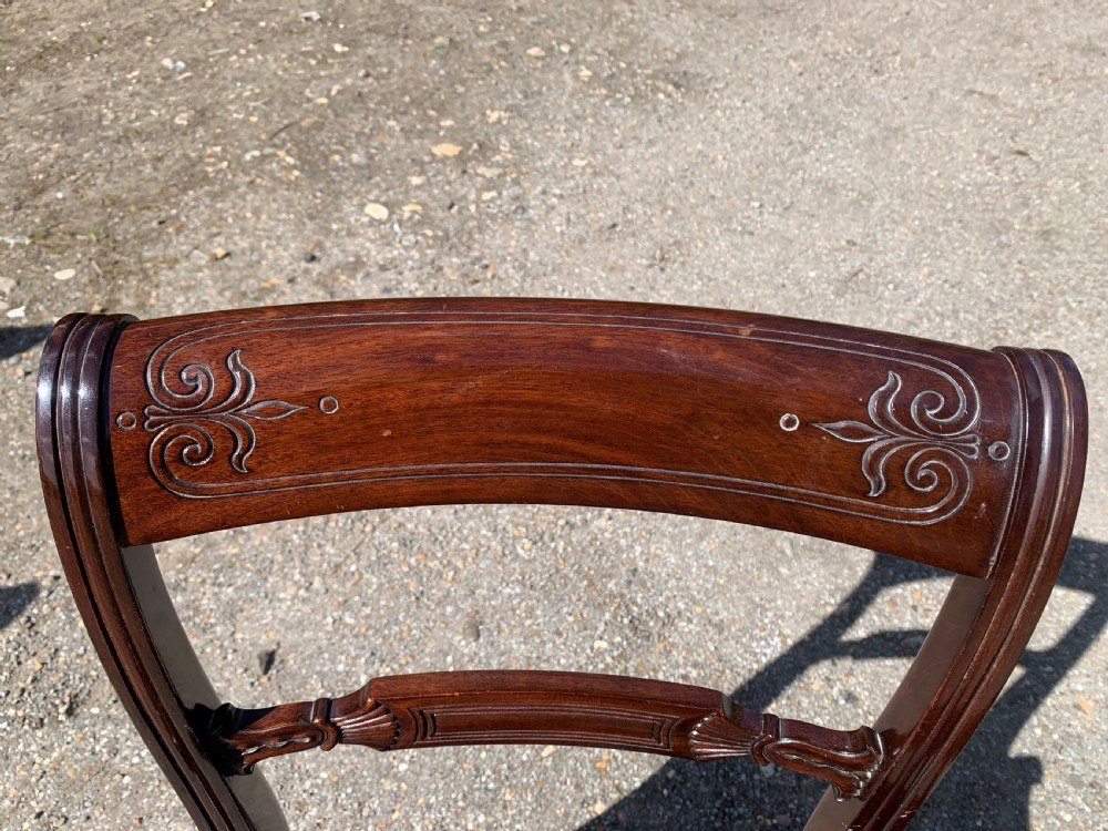 A set of four Regency mahogany dining chairs with carved bar backs, dark brown upholstered seats, and turned front legs. View IX