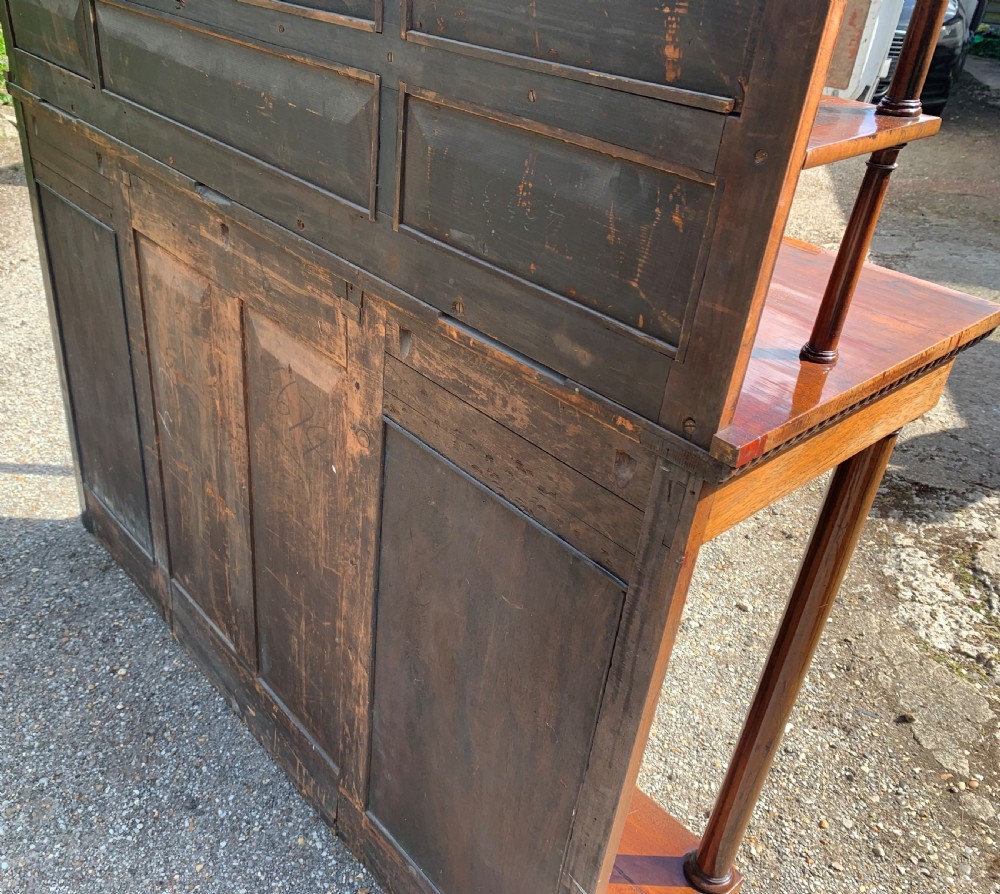 A Regency rosewood breakfront chiffonier cabinet featuring an upper mirrored shelf unit supported by turned columns over central mesh-panelled doors lined with fabric. View VIII