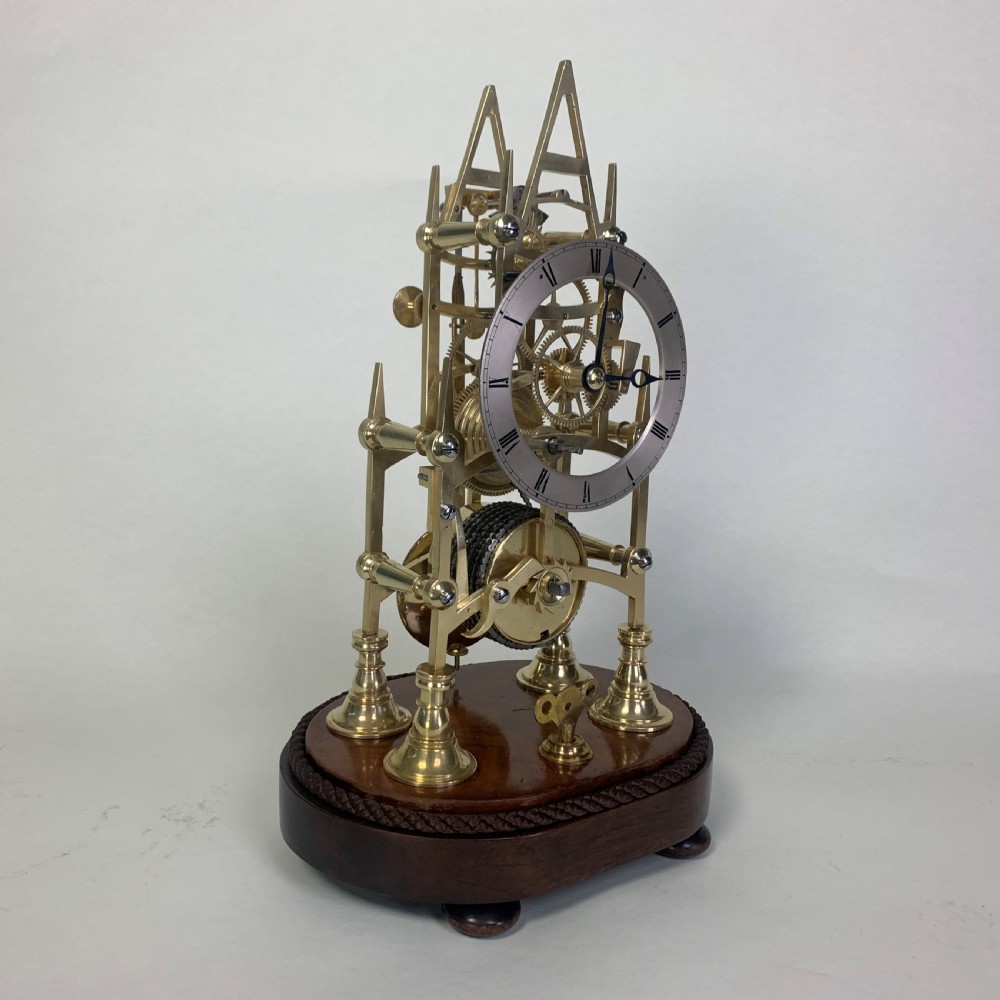 Brass skeleton clock in glass dome
