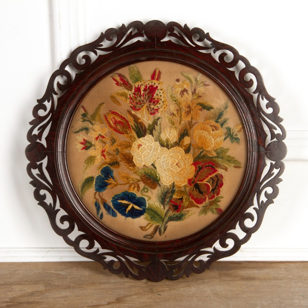 A pair of circular antique floral needlework panels housed within dark mahogany pierced openwork frames. View III