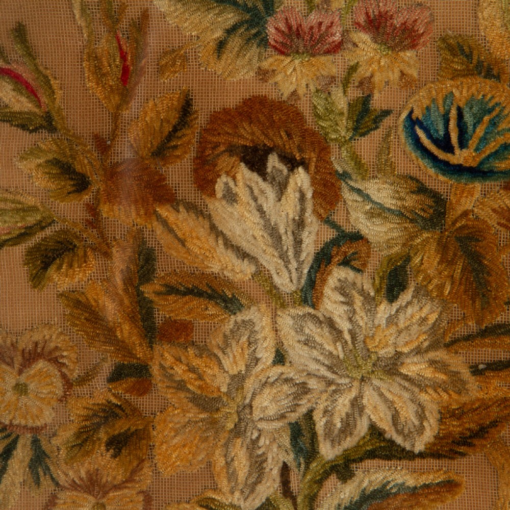 A pair of circular antique floral needlework panels housed within dark mahogany pierced openwork frames. View IV