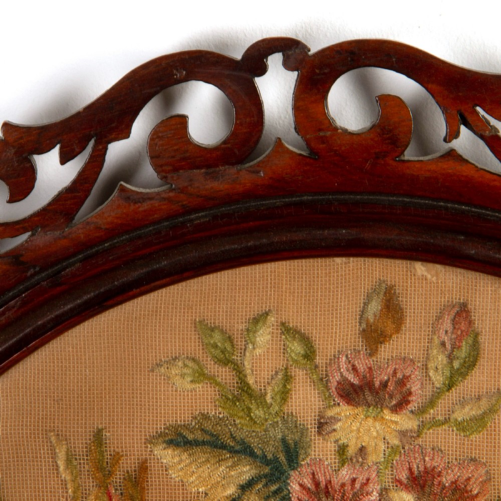 A pair of circular antique floral needlework panels housed within dark mahogany pierced openwork frames. View VI