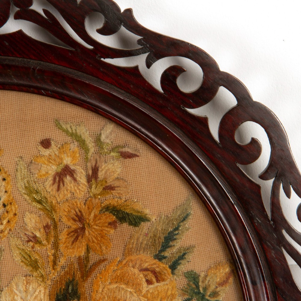 A pair of circular antique floral needlework panels housed within dark mahogany pierced openwork frames. View VII