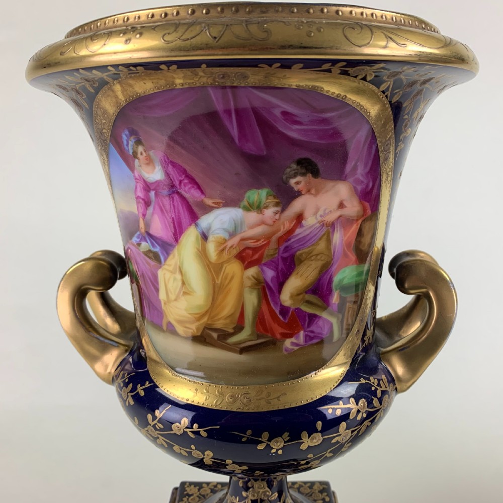 A pair of cobalt blue and gold Vienna porcelain urns with hand-painted classical scenes on square plinths. View IV