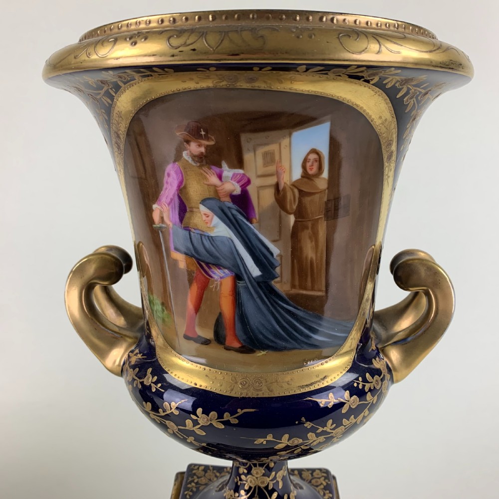 A pair of cobalt blue and gold Vienna porcelain urns with hand-painted classical scenes on square plinths. View V