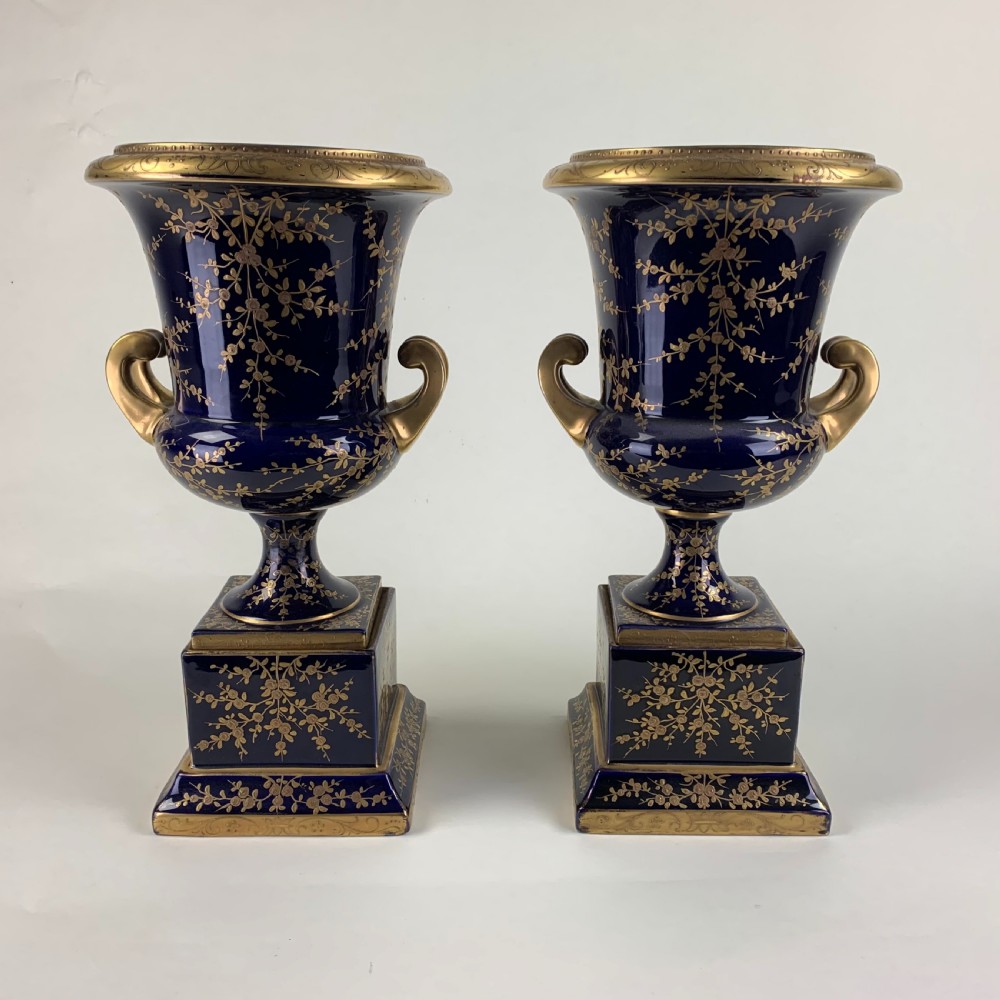 A pair of cobalt blue and gold Vienna porcelain urns with hand-painted classical scenes on square plinths. View VII