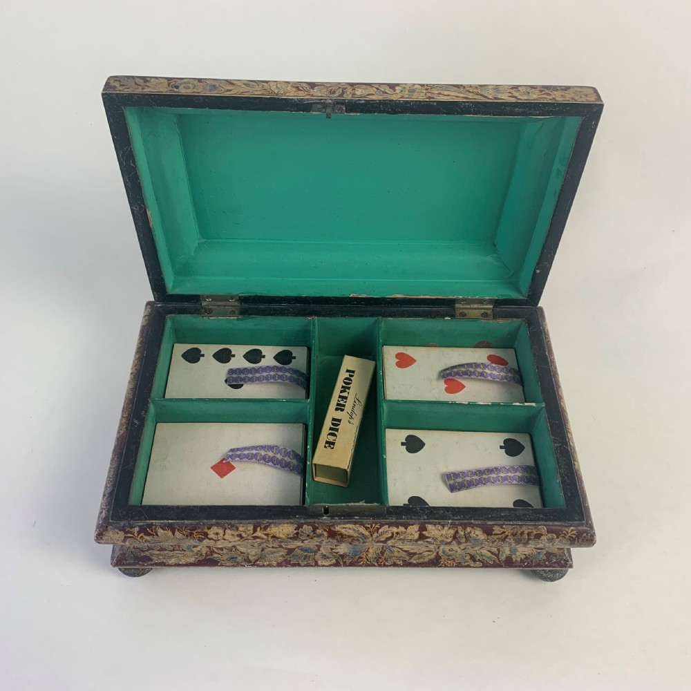 A rectangular early 19th-century Regency wooden games box, hand-painted with intricate botanical patterns in burgundy, gold, and green, featuring a sarcophagus-style lid and small ball feet. View VI
