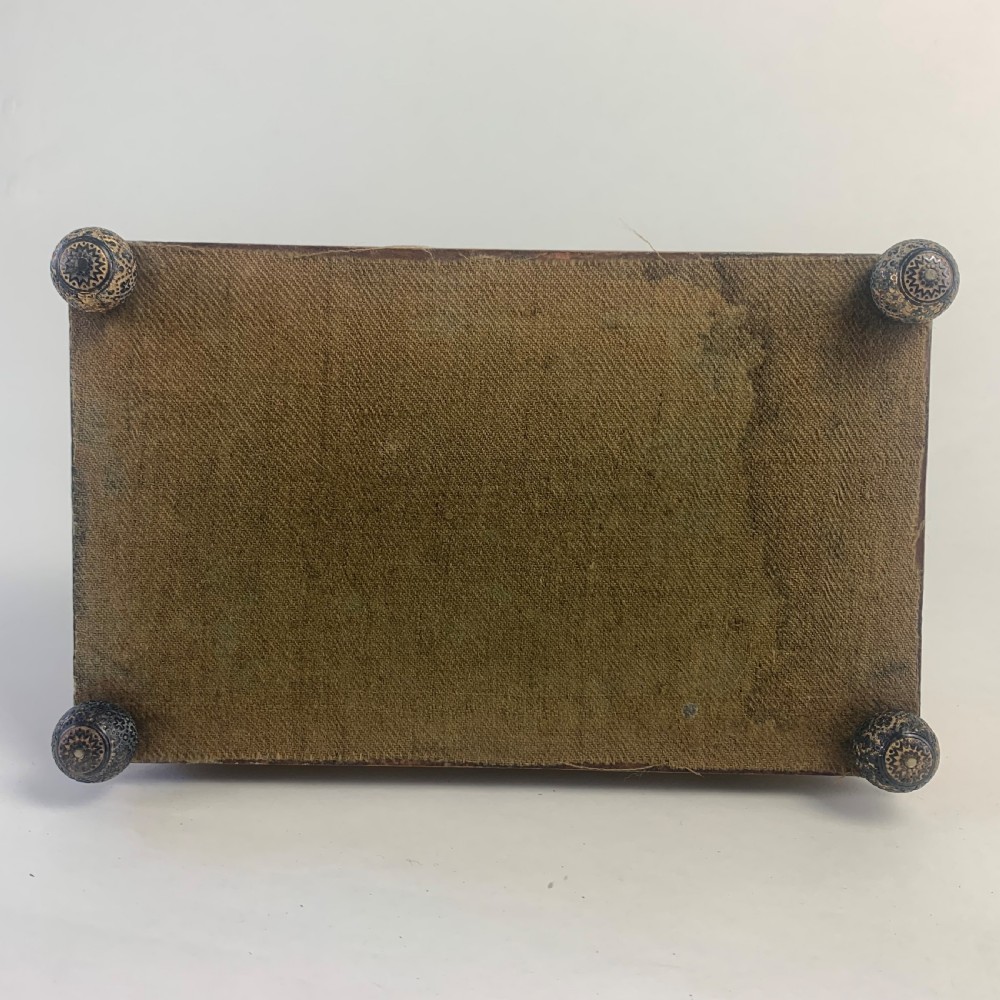 A rectangular early 19th-century Regency wooden games box, hand-painted with intricate botanical patterns in burgundy, gold, and green, featuring a sarcophagus-style lid and small ball feet. View IX