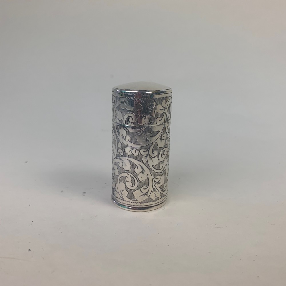 An engraved cylindrical silver scent bottle case with an open hinged lid displaying an internal clear glass bottle with a stopper. View II