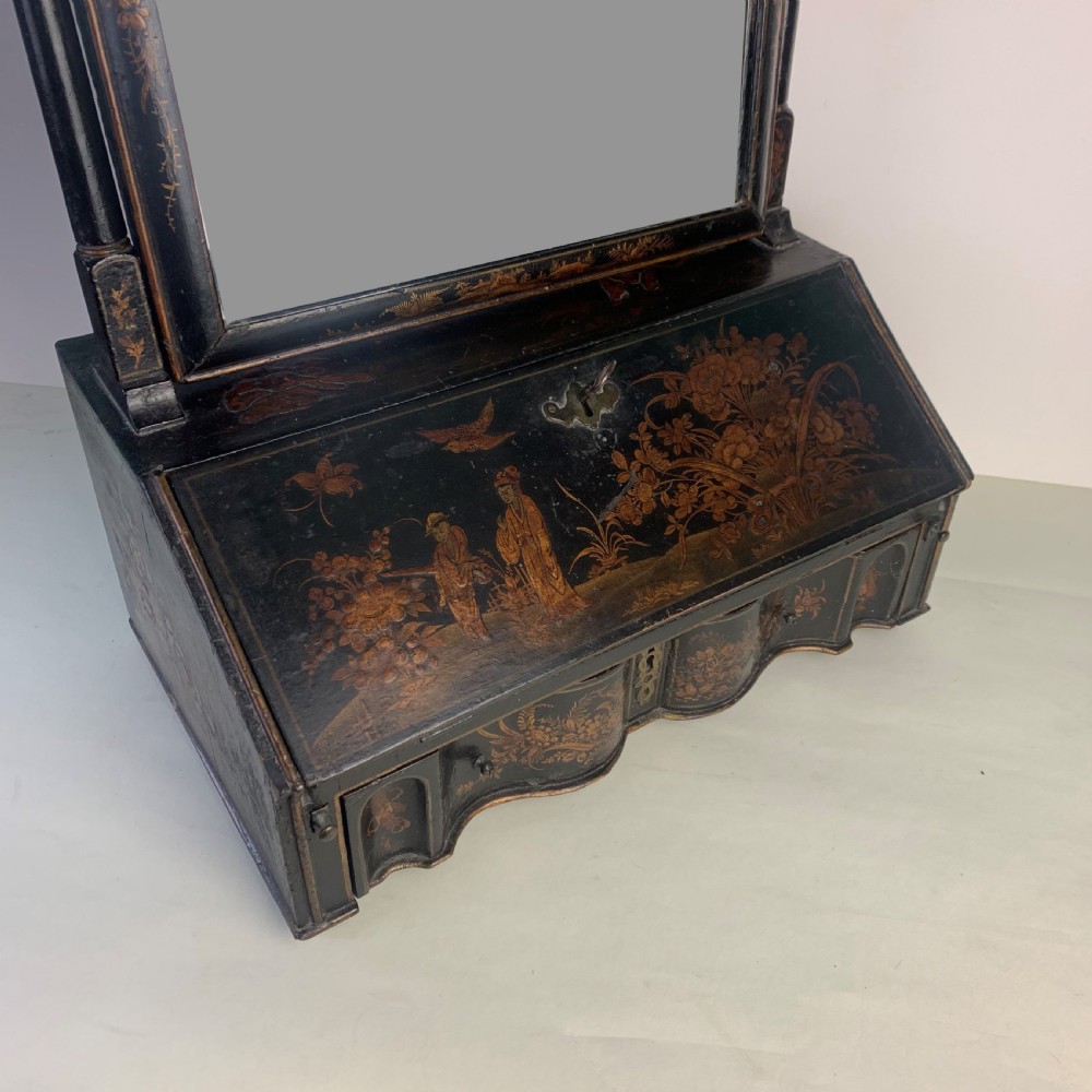 A black lacquered toilet mirror featuring an arched frame and gilded Chinoiserie artwork mounted on a miniature slant-front bureau base. View IV