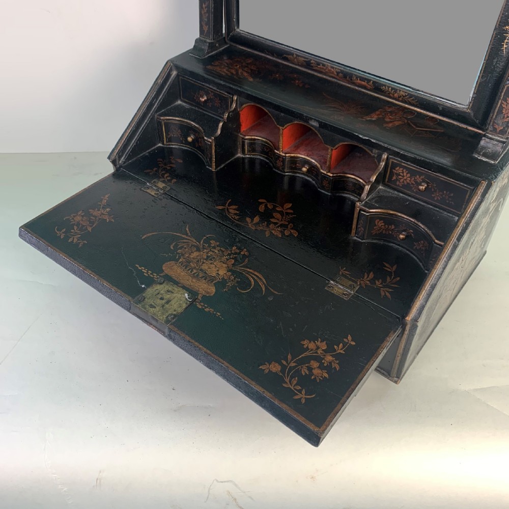 A black lacquered toilet mirror featuring an arched frame and gilded Chinoiserie artwork mounted on a miniature slant-front bureau base. View VII