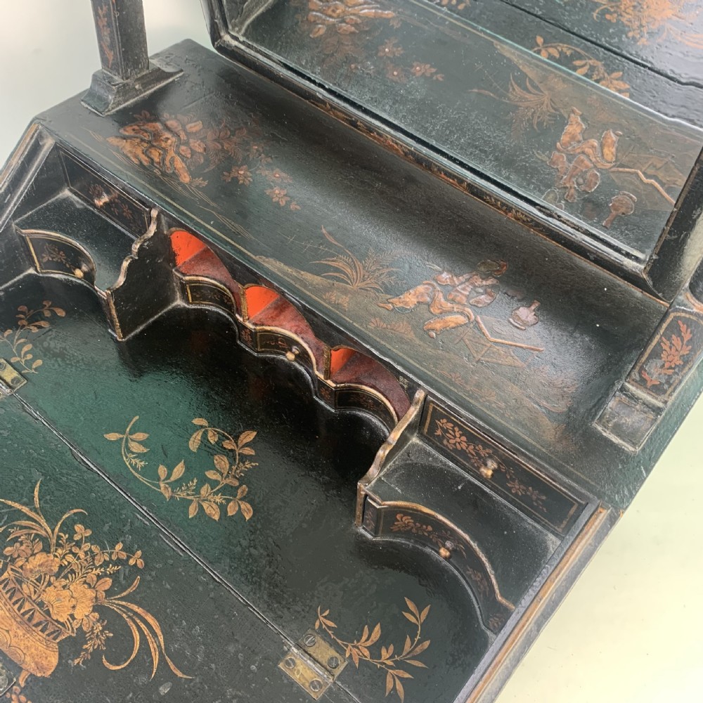 A black lacquered toilet mirror featuring an arched frame and gilded Chinoiserie artwork mounted on a miniature slant-front bureau base. View VIII