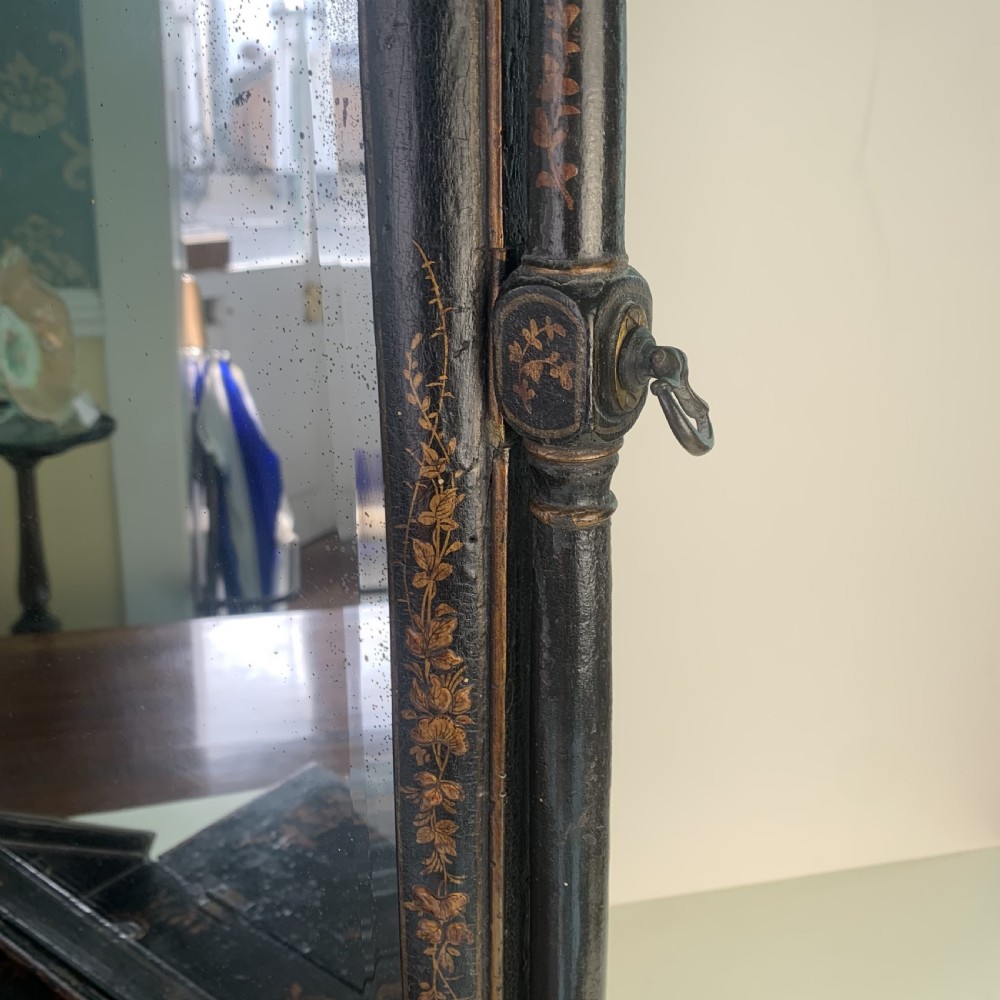 A black lacquered toilet mirror featuring an arched frame and gilded Chinoiserie artwork mounted on a miniature slant-front bureau base. View XII