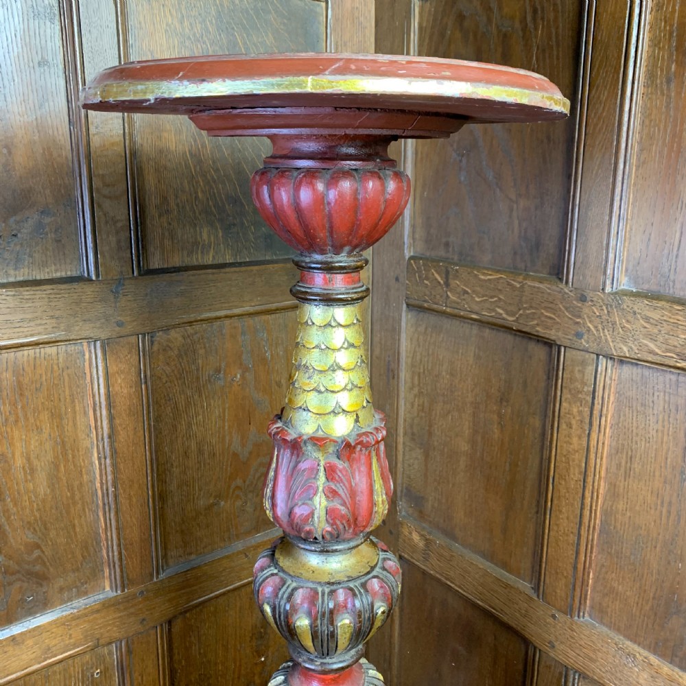 A tall, ornately carved Italian wooden torchiere featuring red and gold polychrome finishes, turned central column sections, and a sculptural scroll base. View IV