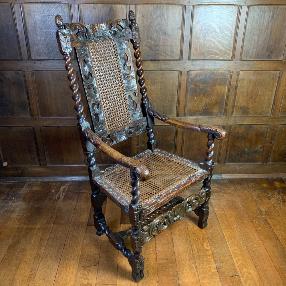 A 17th-century Carolean dark walnut armchair featuring a high backrest with woven cane panels, intricate spiral turned legs, and detailed foliage carving. View II