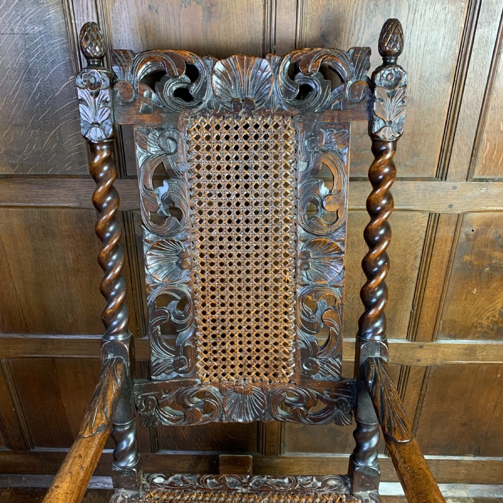 A 17th-century Carolean dark walnut armchair featuring a high backrest with woven cane panels, intricate spiral turned legs, and detailed foliage carving. View III