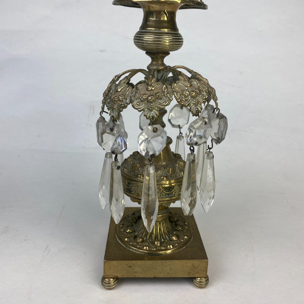 A pair of ornate gilt metal candlesticks featuring square plinth bases, decorative scrollwork rims, and clear cut glass lustre drops hanging around the column. View III
