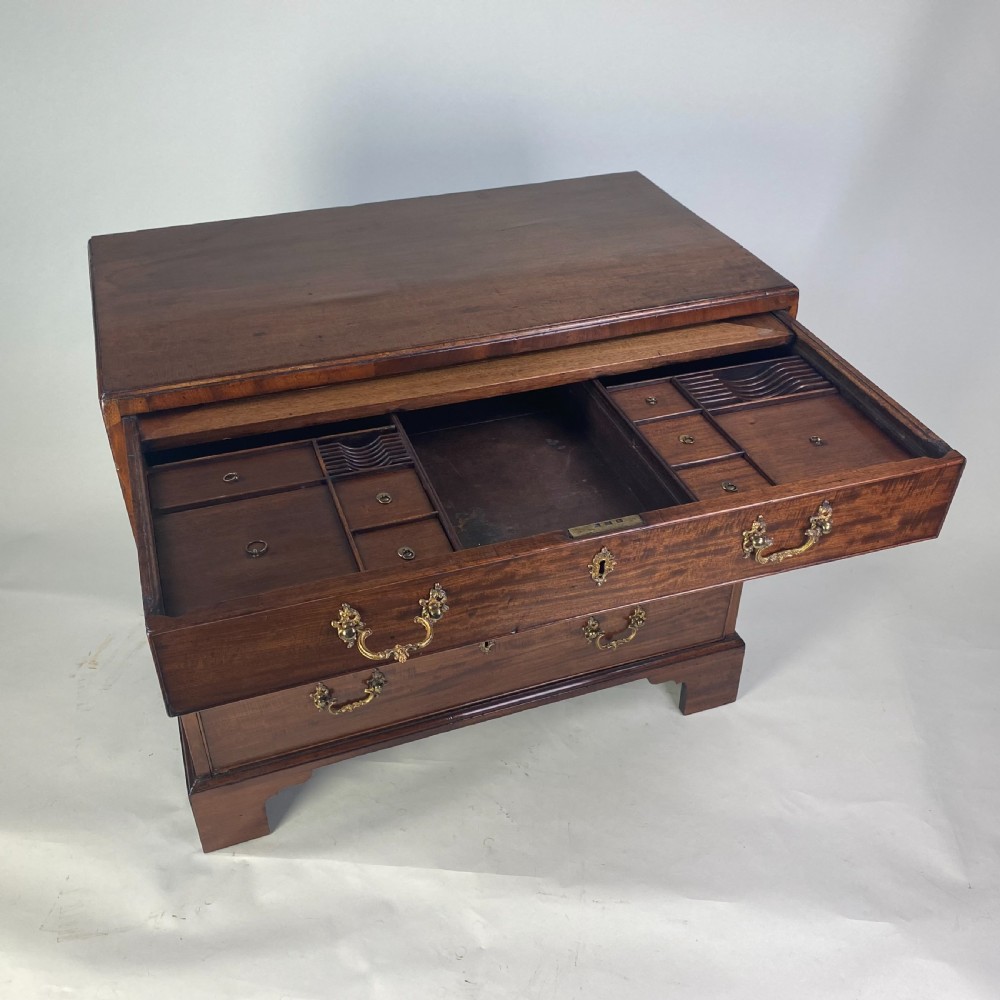 A Georgian Chippendale mahogany chest of drawers featuring four graduated drawers with brass handles, resting on bracket feet. View VI