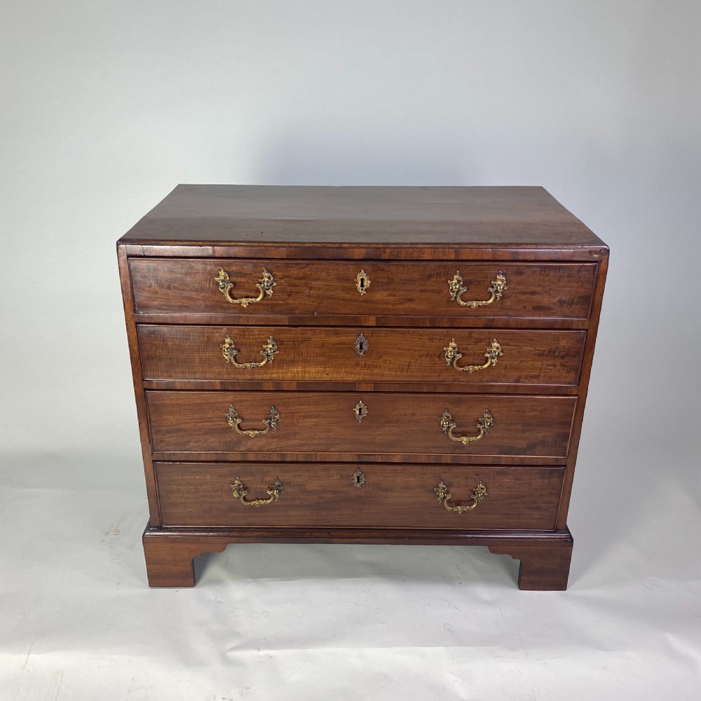 A Georgian Chippendale mahogany chest of drawers featuring four graduated drawers with brass handles, resting on bracket feet. View VII
