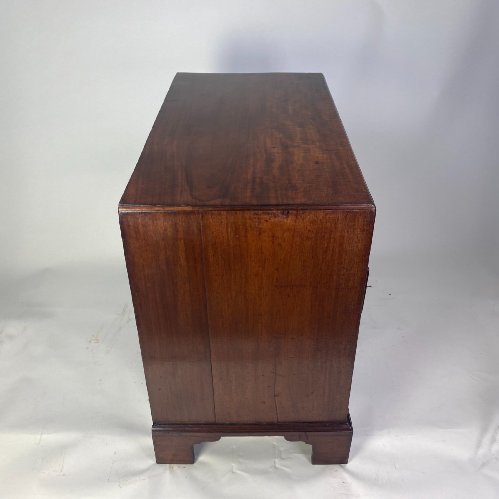 A Georgian Chippendale mahogany chest of drawers featuring four graduated drawers with brass handles, resting on bracket feet. View IX