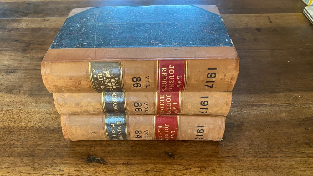 A continuous shelf run of uniform antique leather-bound Law Journal Reports featuring tan calfskin spines, contrasting red and dark labels, and gilt lettering. View III