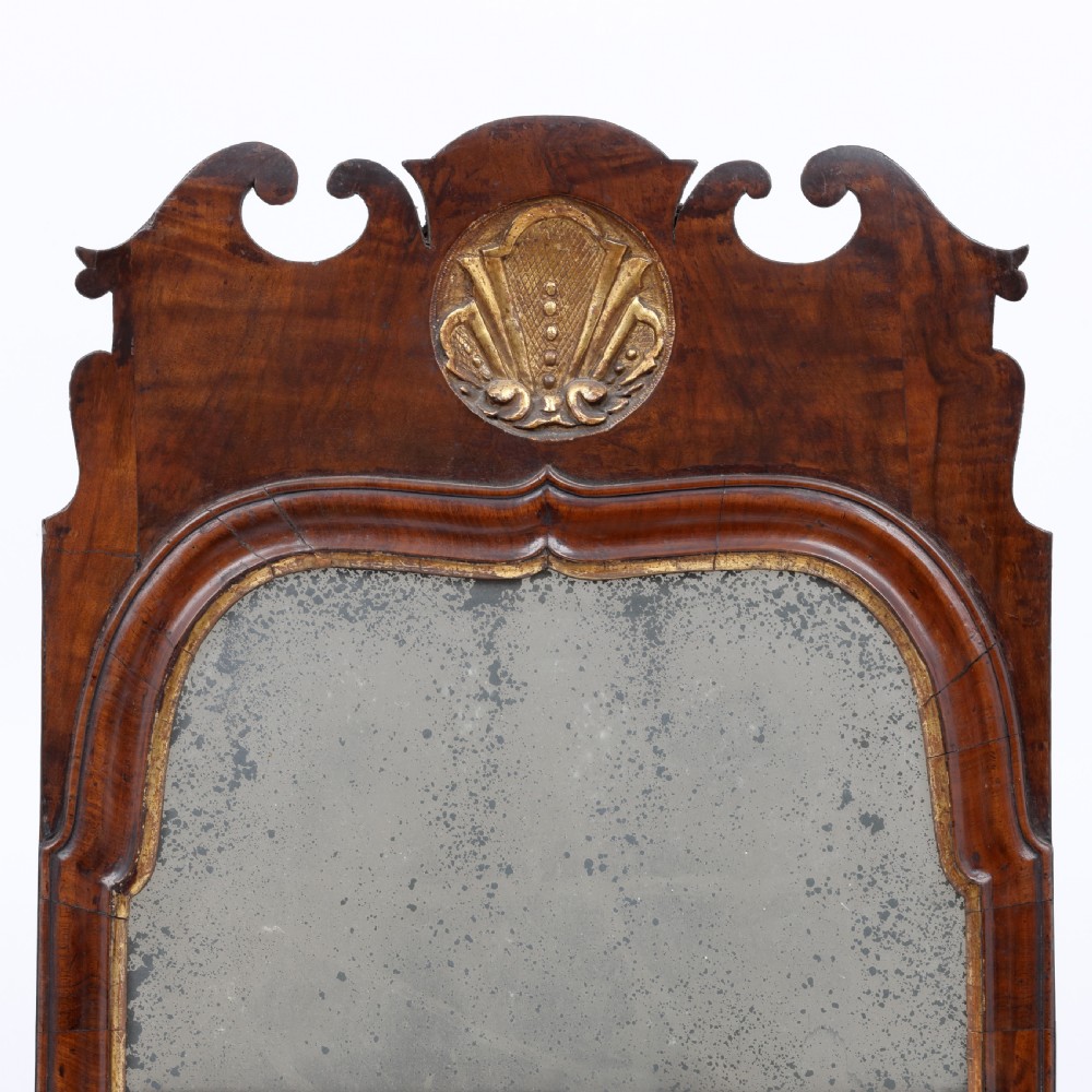 A tall Queen Anne walnut pier mirror featuring an arched frame with a carved gilded shell crest and two-section foxed mirror glass. View II
