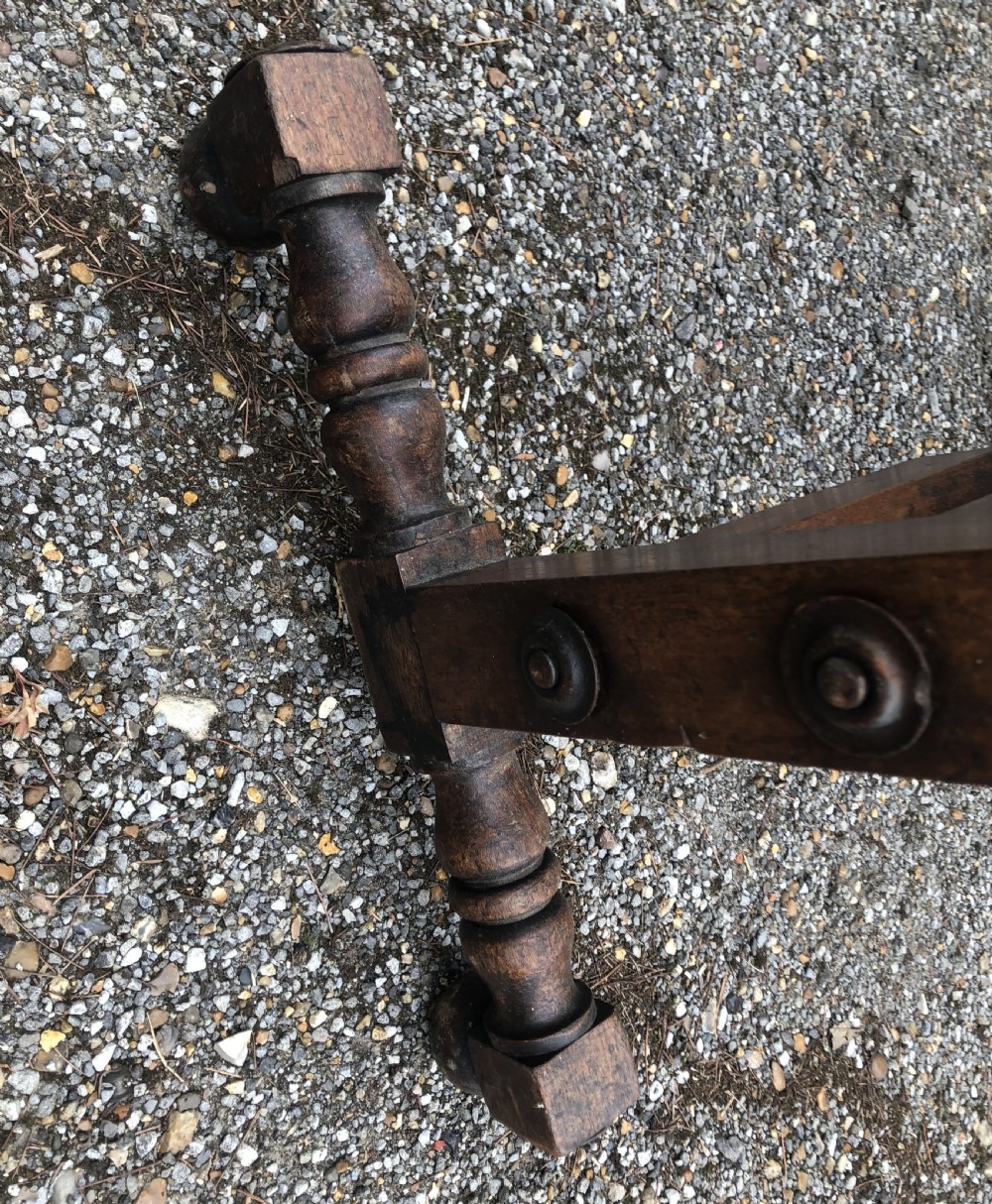 A nineteenth-century wooden rocking cradle featuring turned spindles, solid headboards, and a standing frame with castors. View XI