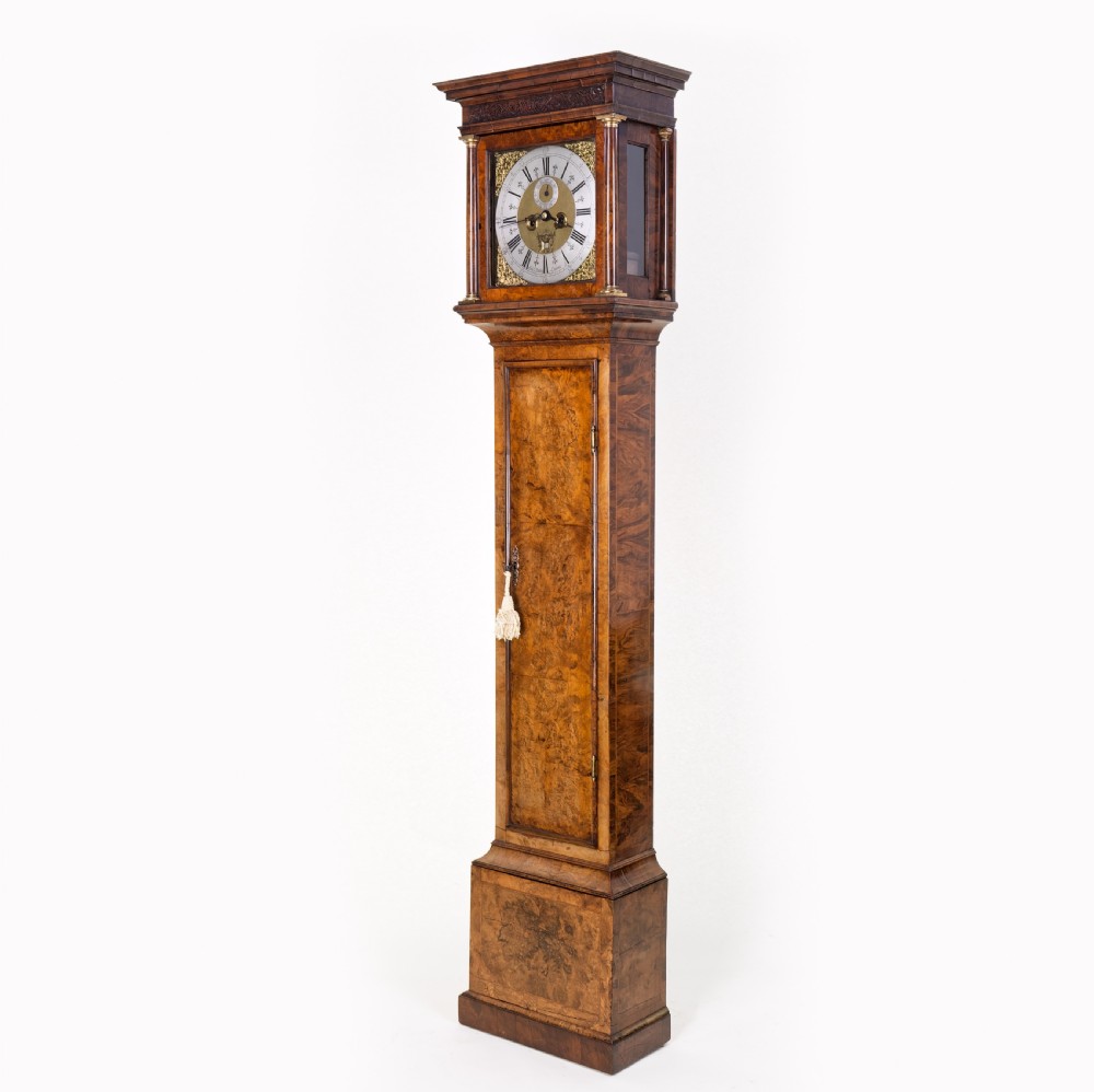 An eighteenth-century burr walnut longcase clock featuring a square brass dial, silvered chapter ring, and moulded pedestal base. View II
