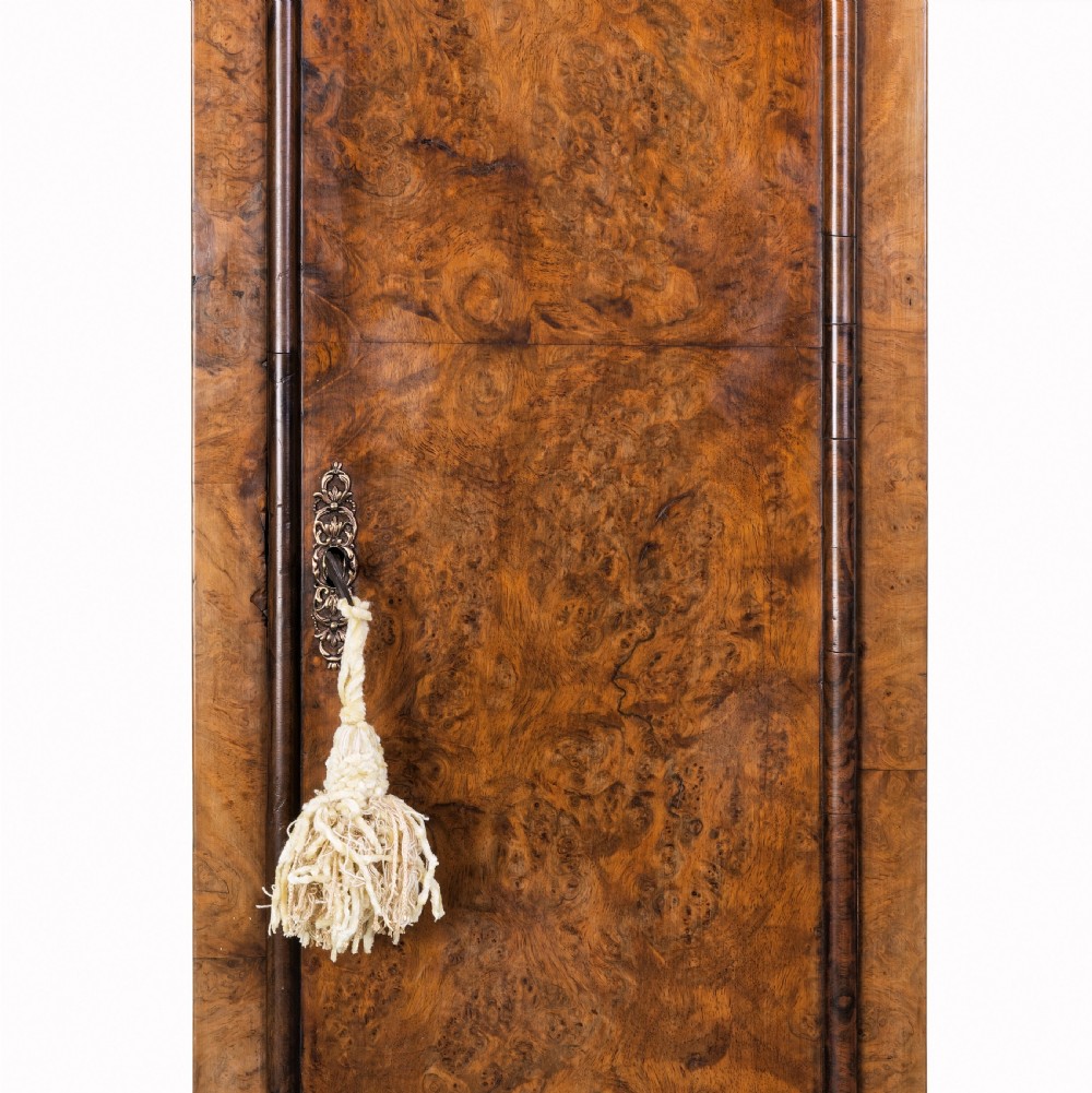 An eighteenth-century burr walnut longcase clock featuring a square brass dial, silvered chapter ring, and moulded pedestal base. View IV