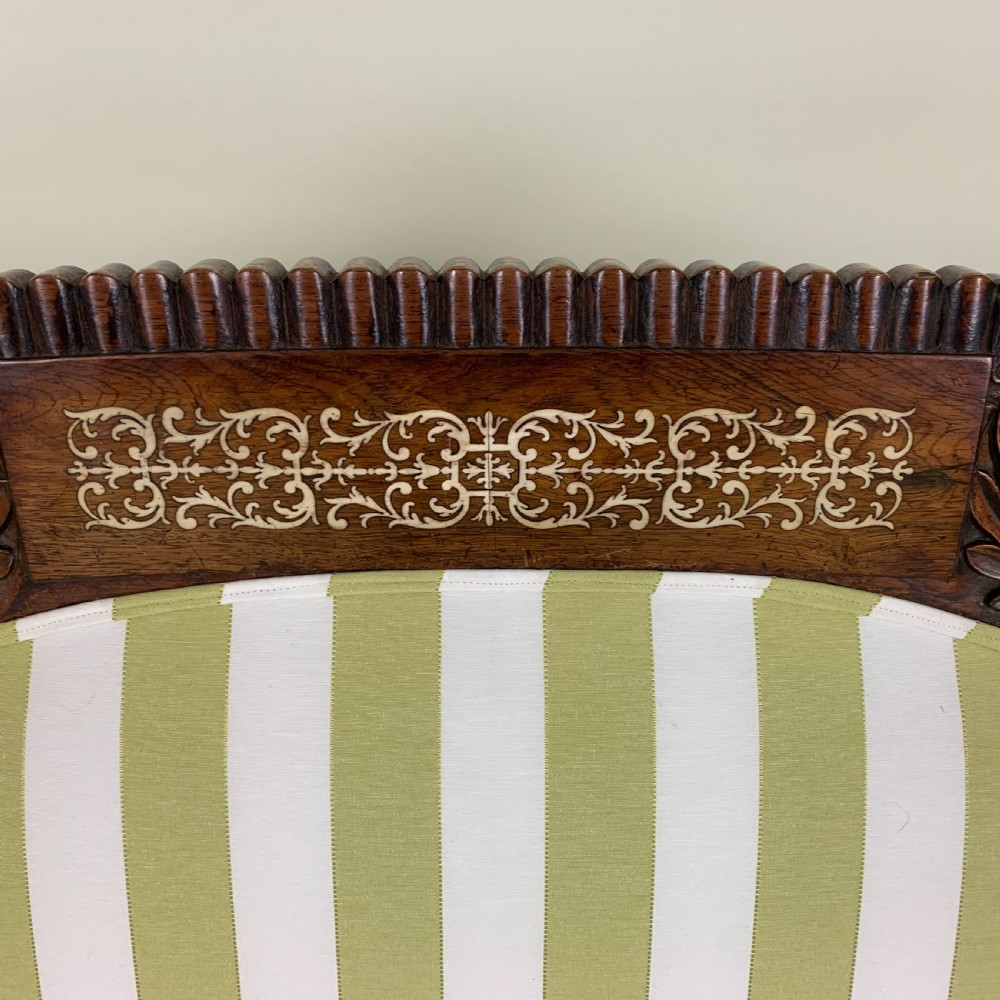 A Regency mahogany scroll end sofa upholstered in green and white striped fabric with matching bolster cushions and turned legs on brass castors. View VII