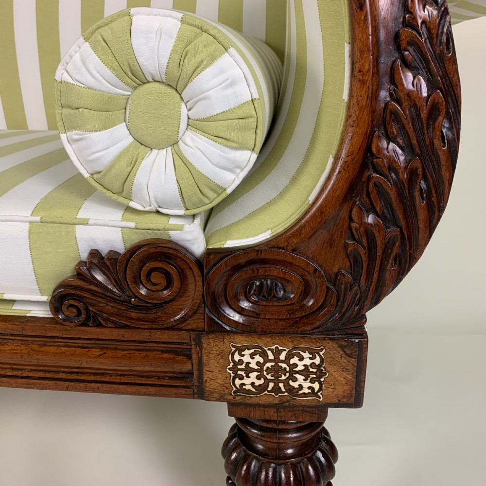 A Regency mahogany scroll end sofa upholstered in green and white striped fabric with matching bolster cushions and turned legs on brass castors. View VIII