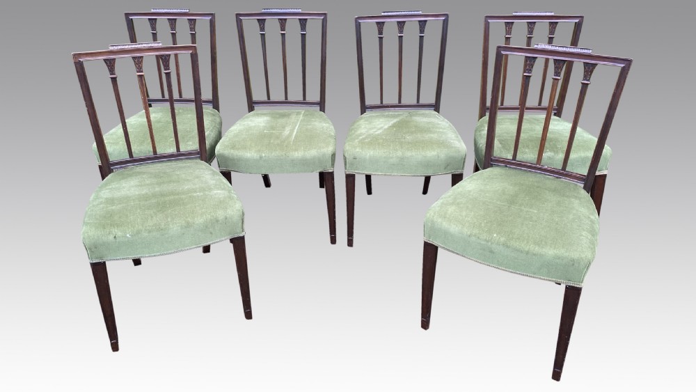 A set of seven mahogany dining chairs, including six side chairs and one carver armchair, with square backs and green velvet seats. View II
