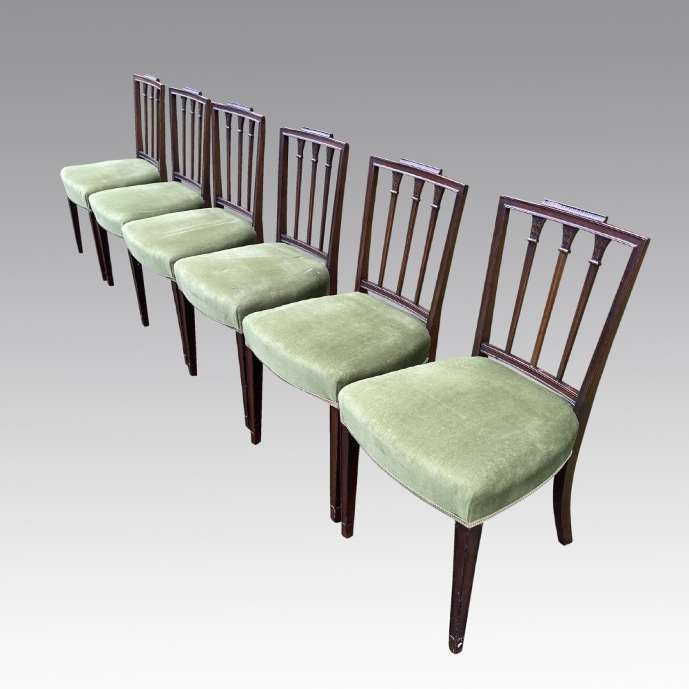 A set of seven mahogany dining chairs, including six side chairs and one carver armchair, with square backs and green velvet seats. View IV