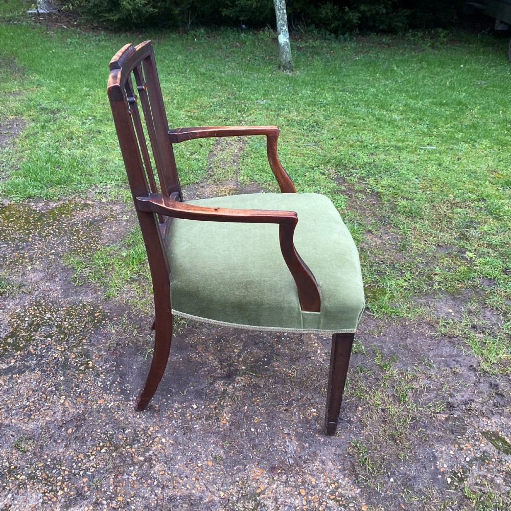 A set of seven mahogany dining chairs, including six side chairs and one carver armchair, with square backs and green velvet seats. View V
