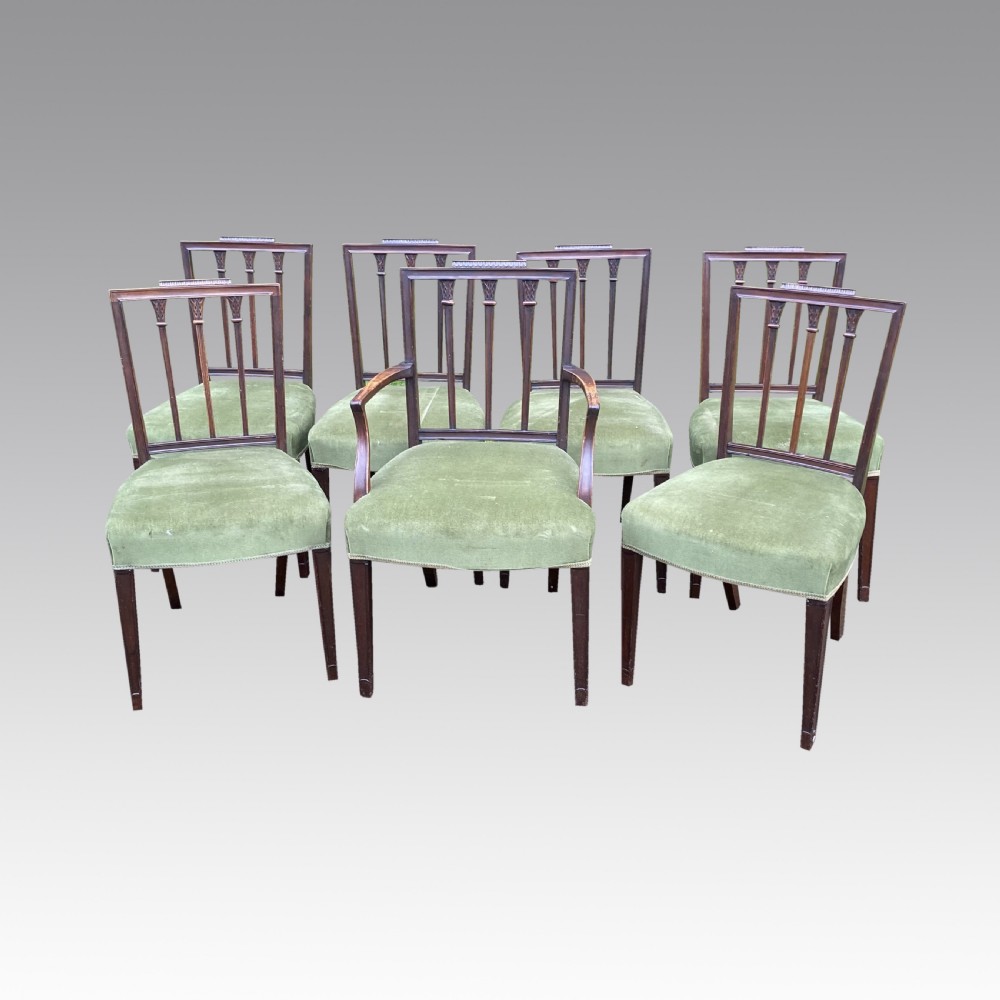 A set of seven mahogany dining chairs, including six side chairs and one carver armchair, with square backs and green velvet seats. View VI
