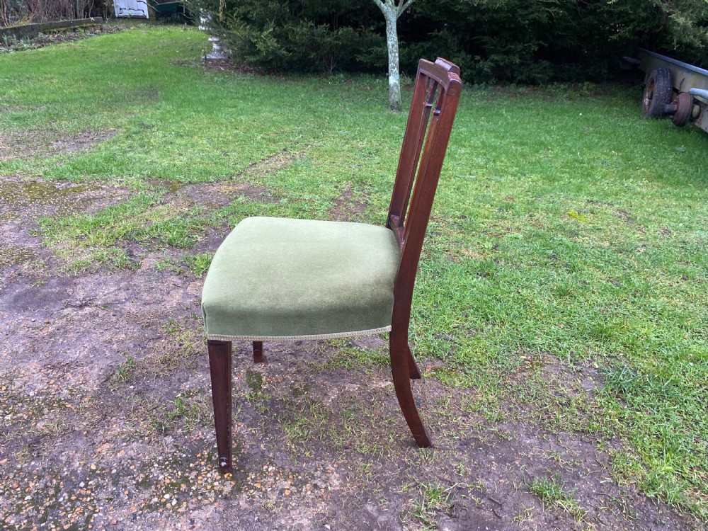 A set of seven mahogany dining chairs, including six side chairs and one carver armchair, with square backs and green velvet seats. View XI
