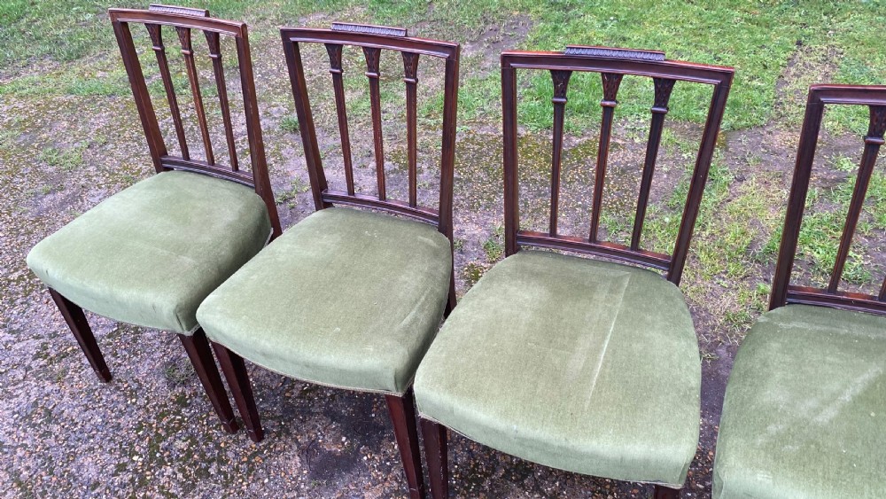 A set of seven mahogany dining chairs, including six side chairs and one carver armchair, with square backs and green velvet seats. View XV