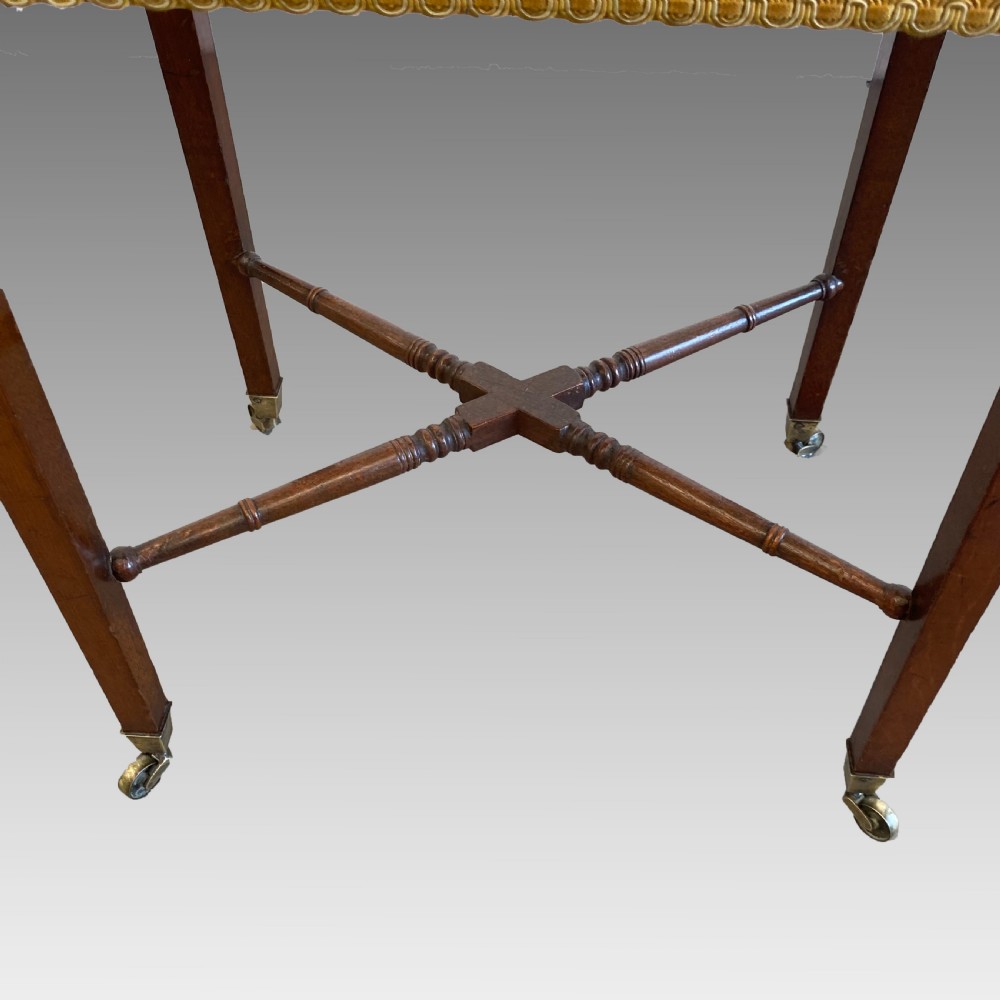 A Georgian mahogany needlework table featuring three drawers, a fabric work pouch, turned X-frame stretcher, and brass castors. View IX