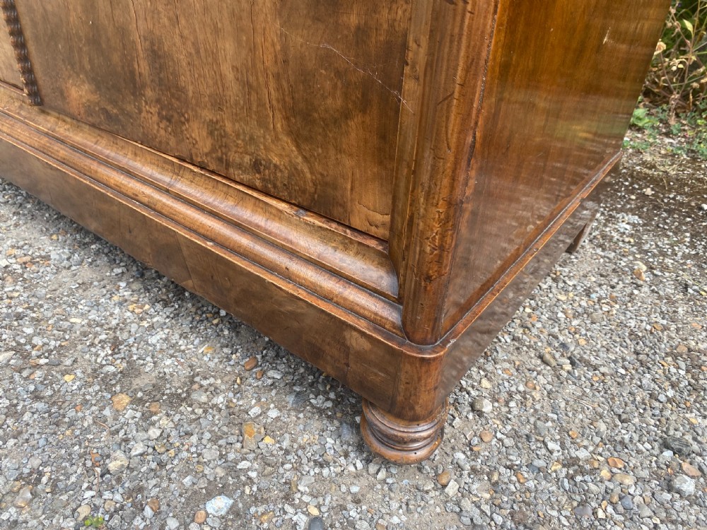A tall antique burr walnut bonnetiere wardrobe cupboard featuring double panelled doors and a moulded top cornice. View XI