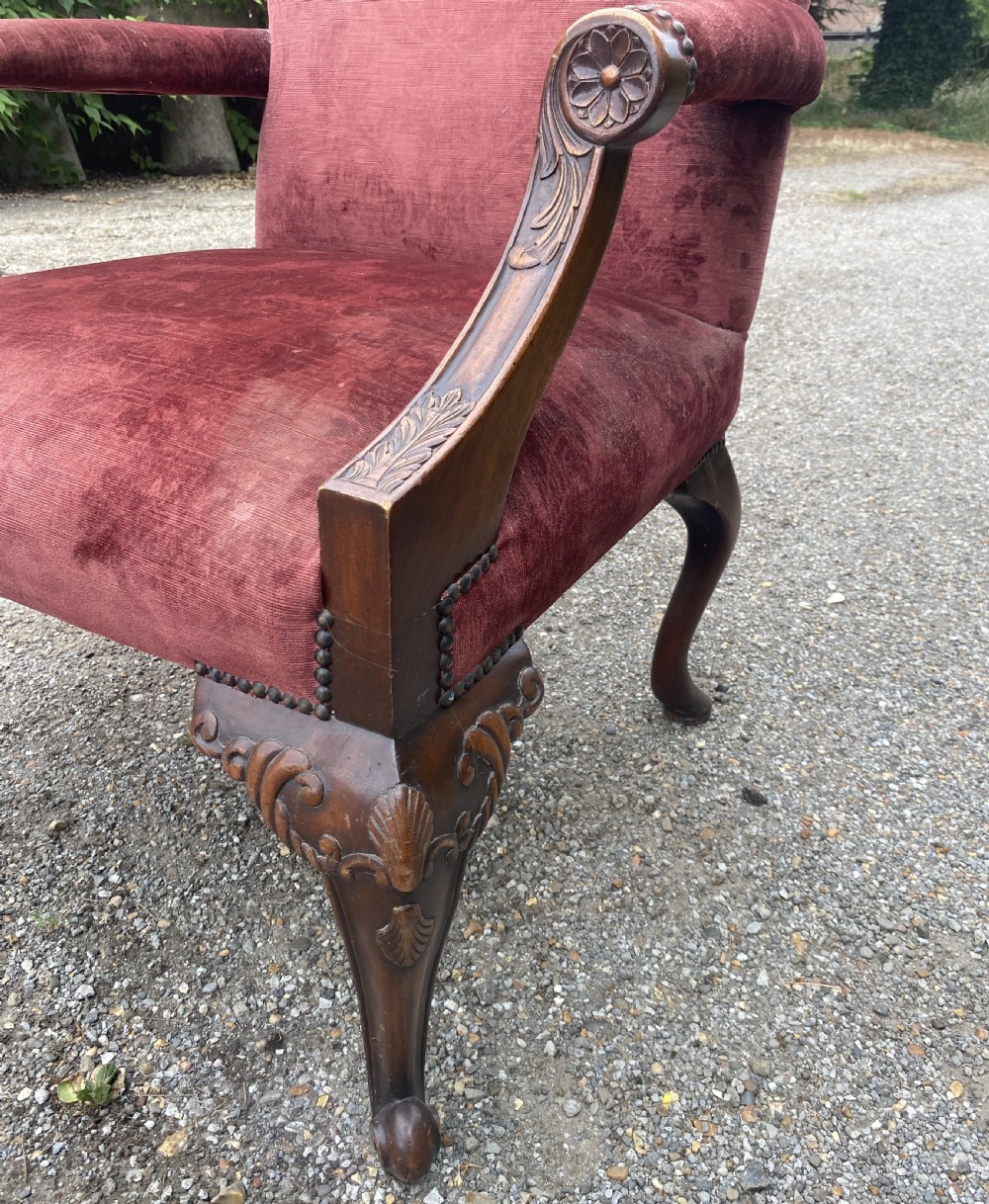 A 19th-century George III style Gainsborough armchair featuring rose pink velvet upholstery, open carved mahogany arms, and carved cabriole legs. View XVI