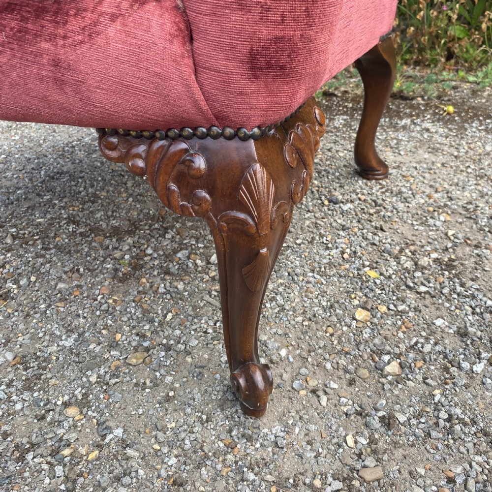 A 19th-century George III style wingback armchair upholstered in rose pink velvet with carved mahogany cabriole front legs and brass stud trimming. View XI