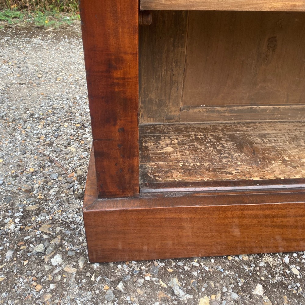 An English Regency mahogany low open bookcase featuring carved pilasters, adjustable shelves, and a solid plinth base. View VII