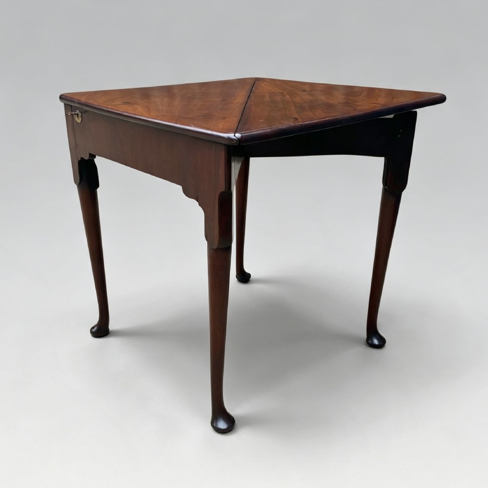 An 18th-century George II triangular mahogany handkerchief table featuring tapered turned legs terminating in pad feet and a keyhole frieze. View III