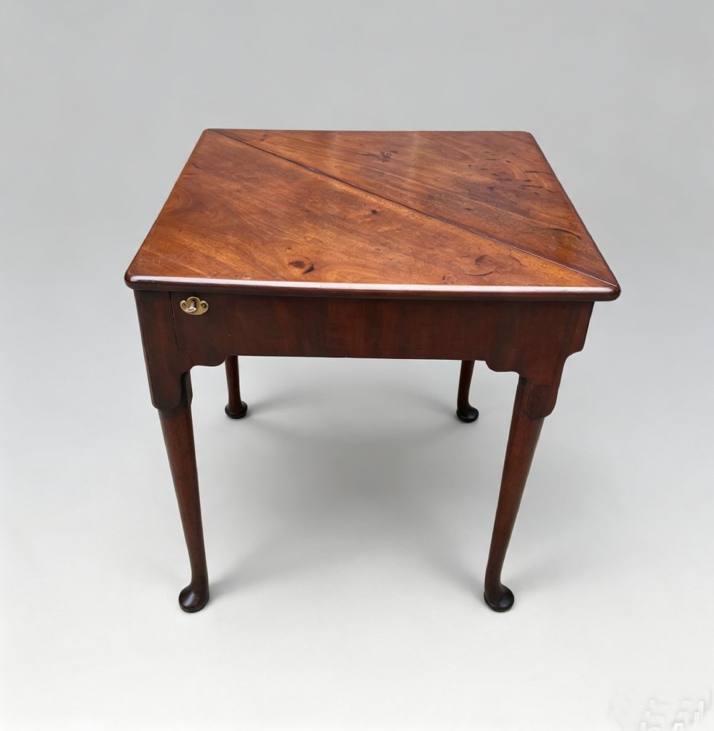 An 18th-century George II triangular mahogany handkerchief table featuring tapered turned legs terminating in pad feet and a keyhole frieze. View IV