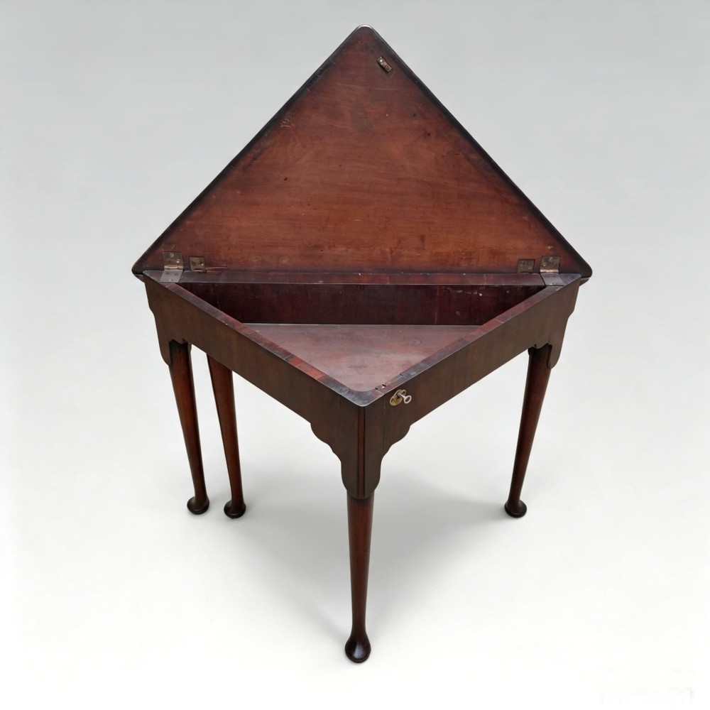 An 18th-century George II triangular mahogany handkerchief table featuring tapered turned legs terminating in pad feet and a keyhole frieze. View VIII