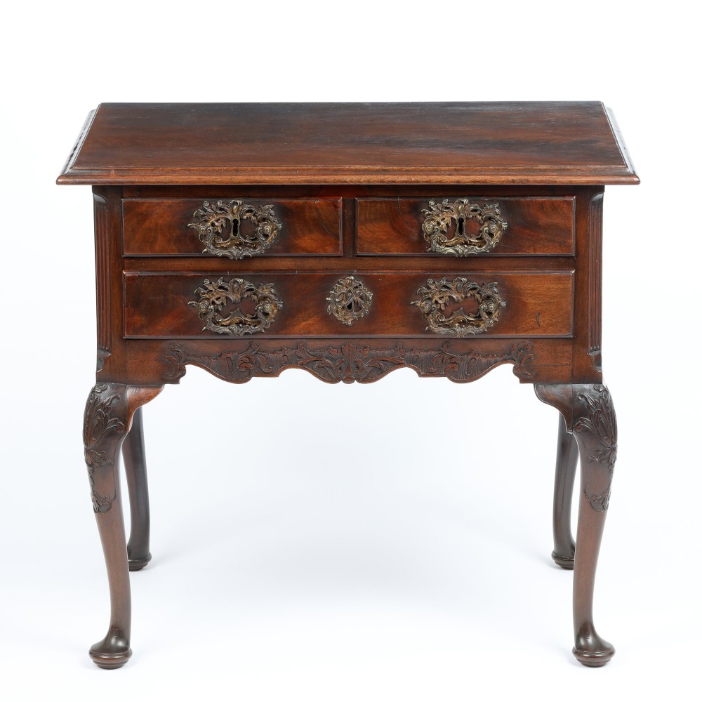 A George II mahogany lowboy side table featuring three drawers, ornate brass backplate handles, carved cabriole legs, and pad feet. View IV