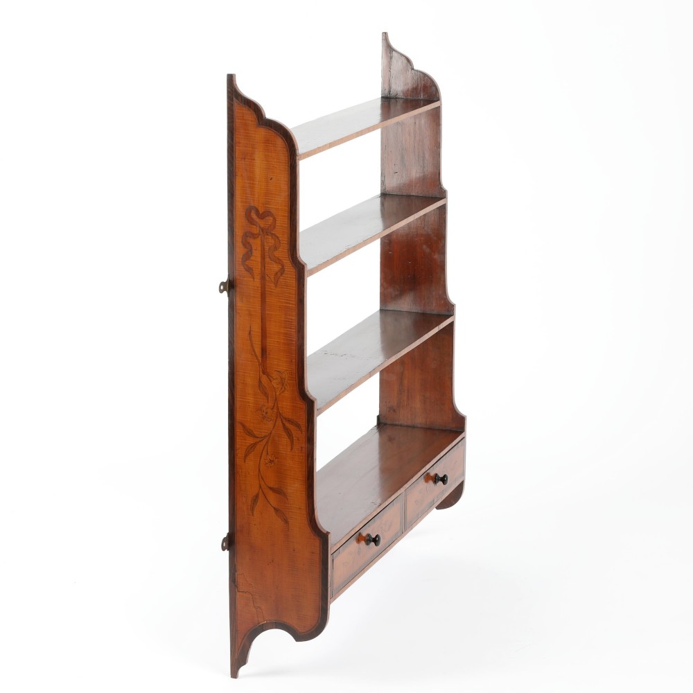 An antique satinwood and mahogany wall-hanging waterfall shelf featuring three open shelves, botanical marquetry inlays, and two small drawers at the base. View II