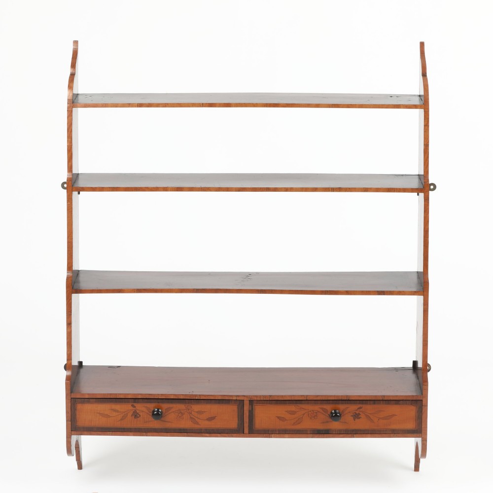 An antique satinwood and mahogany wall-hanging waterfall shelf featuring three open shelves, botanical marquetry inlays, and two small drawers at the base. View VI